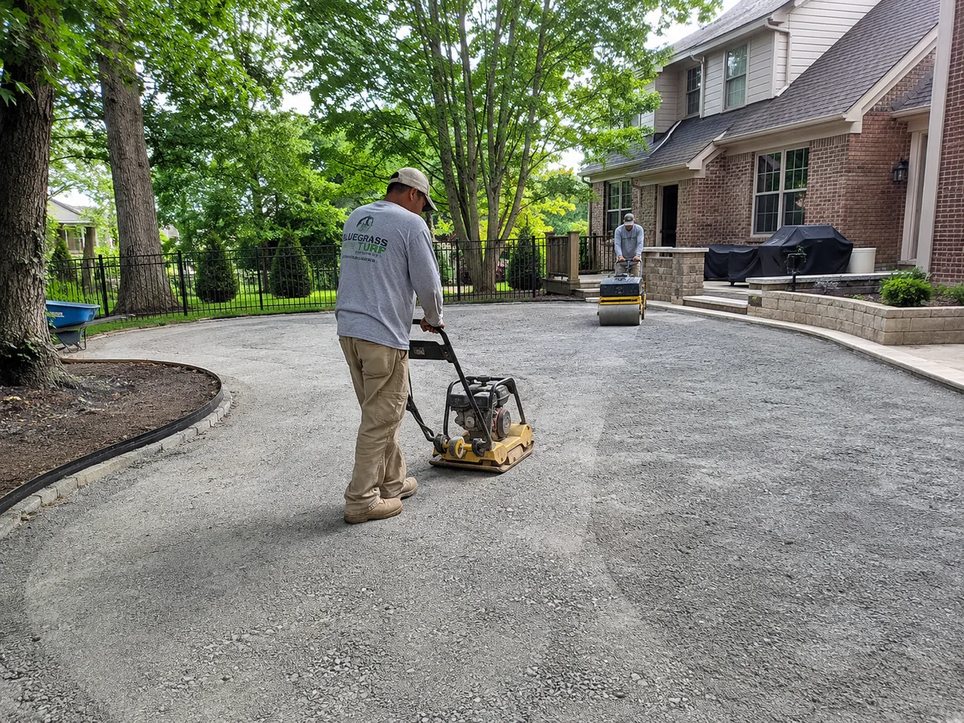 Crew installing the aggregate base for an artificial turf lawn